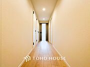 上質感漂う廊下。居住者の帰り、訪れる方を優しく迎える・安らぎに満ちた生活空間を予感させる。
