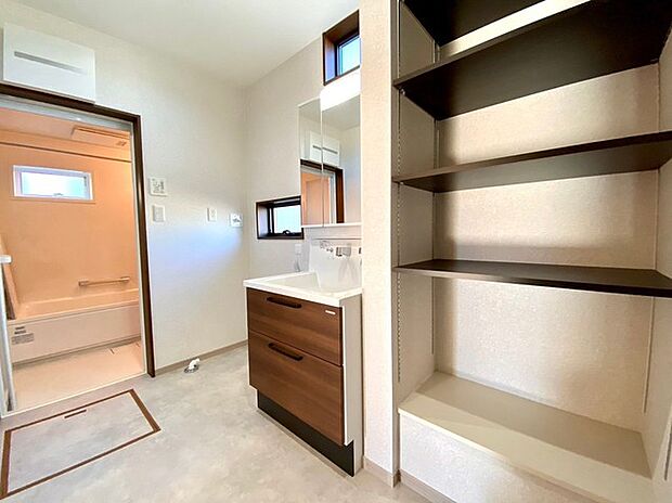 ゆとりのある洗面脱衣室(施工例) 約3帖分で作業もゆったりと行えます。可動棚のリネン庫を標準装備。