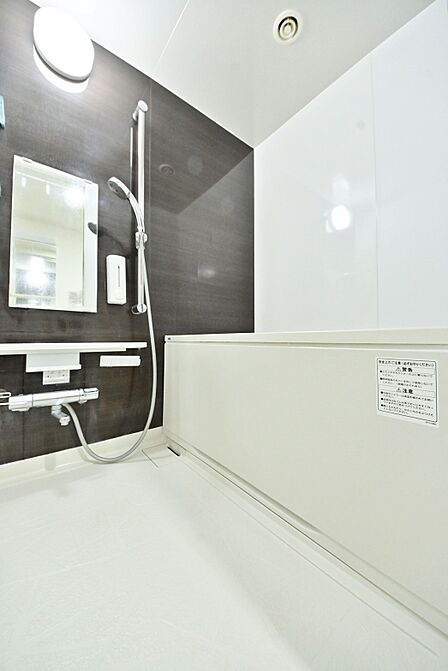 木目調パネルが落ち着きを演出するバスルーム。ゆったりとした浴槽で、一日の疲れをしっかり癒せます。