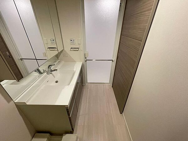 十分なカウンタースペースがある洗面化粧台は実用的です・洗濯機スペースには収納が設置されています