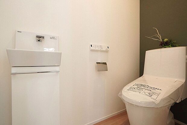 オリーブグリーンのアクセントクロスが貼られた１階トイレ。グリーンには心を落ち着かせる作用があります