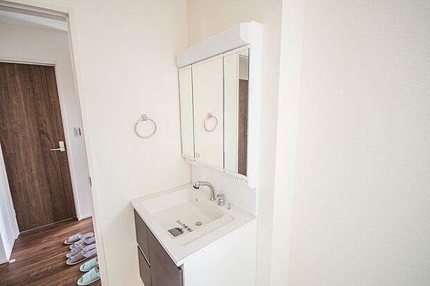 大きく見やすい三面鏡で清潔感ある洗面台は、身だしなみチェックや肌のお手入れに最適です。何かと物が増える場所だからこそ、スッキリと見映えの良い空間に拵えました。