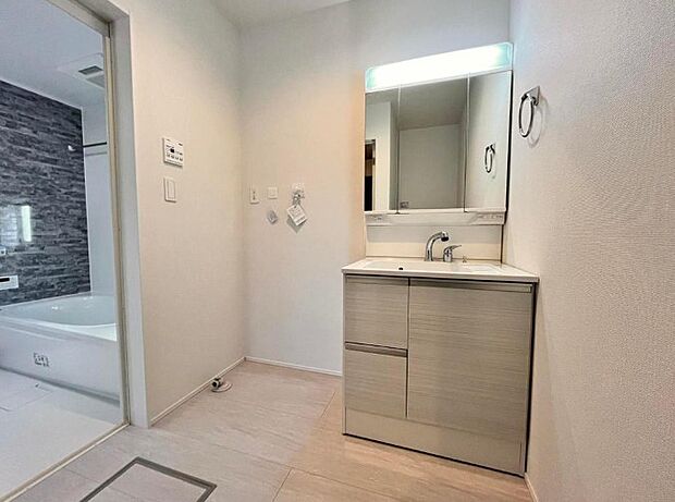 三面鏡洗面化粧台。ミラーを手前に引けば、楽な姿勢で髭剃りやメイクができます。合わせ鏡にすればヘアスタイルのチェックもラクラク。洗面化粧台のミラー裏にはたっぷり入る収納スペースを設けています。