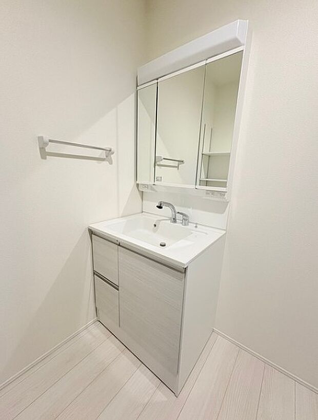 大きく見やすい三面鏡で清潔感ある洗面台は、身だしなみチェックや肌のお手入れに最適です。何かと物が増える場所だからこそ、スッキリと見映えの良い空間に拵えました。