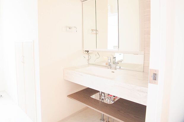 大きく見やすい三面鏡で清潔感ある洗面台は、身だしなみチェックや肌のお手入れに最適です。何かと物が増える場所だからこそ、スッキリと見映えの良い空間に拵えました。