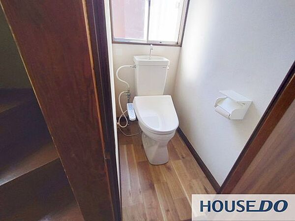 温水洗浄便座付きのトイレです。木目調の落ち着いた空間です。