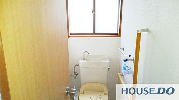 手すりと窓のある明るいトイレ。ご年配の方にも使いやすい設計です。