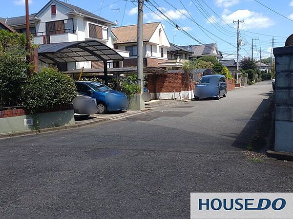 空が開ける前面道路。落ち着いた戸建て中心の住宅街に位置します。