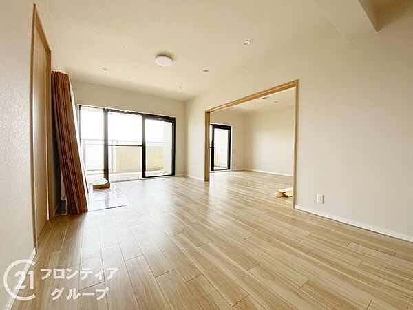 大きな窓から自然光がたっぷりと注ぎ込むリビングは、家族が集う中心にふさわしい開放感に満ちています。隣接するお部屋との繋がりもスムーズで、用途に合わせて自由に空間を使い分けられます