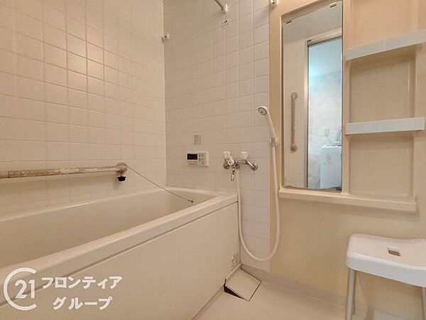 清潔感に満ちた白を基調としたバスルームです。ゆったりと足を伸ばせる浴槽で、一日の疲れを解きほぐす至福のリラックスタイムを過ごせます。機能的な棚も配置され、バス用品の整理も容易です