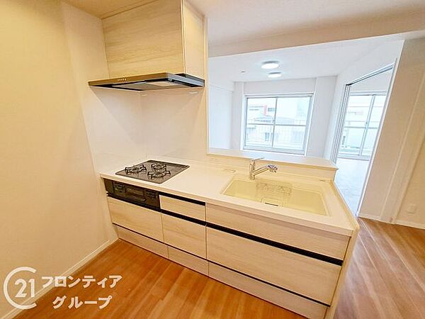 広々としたカウンターが魅力のキッチンです。白を基調とした清潔感あふれるデザインで、毎日の料理も楽しくなりそうです。収納もたっぷりと確保されており、常にすっきりとした空間を保つことができます
