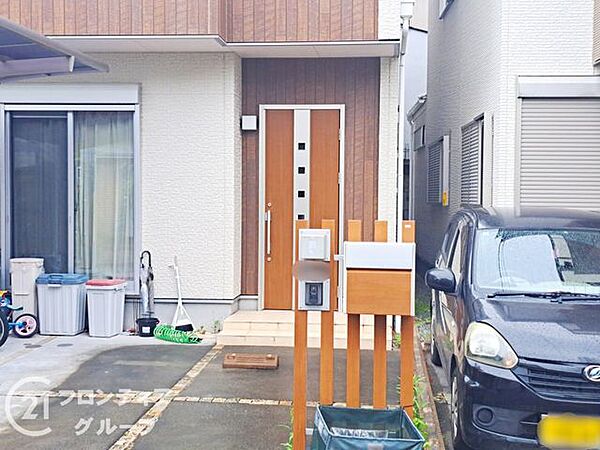 屋根付きのポーチが設置されており、雨の日でも濡れずに落ち着いて出入りできます。玄関周りは常に明るく、ご家族や大切なお客様を温かく迎え入れる心地よい空間となっています