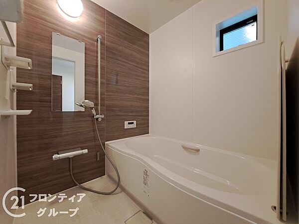 落ち着いた木目調のアクセントパネルが、リラックスタイムを上質に彩る浴室です。広々とした浴槽でゆったりと足を伸ばし、一日の疲れを心ゆくまで癒やせます。