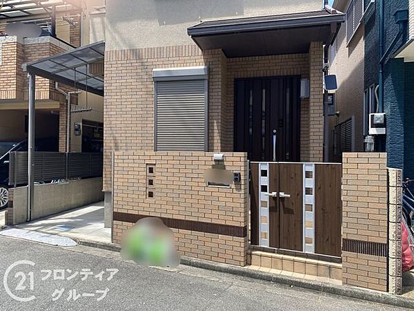 プライバシーに配慮された目隠し壁と、統一感のあるレンガ調のデザインが高級感を演出する玄関先です。落ち着いた木目調のドアが家族やゲストを優しく迎え、日々の暮らしに品格と安心感を与えてくれます