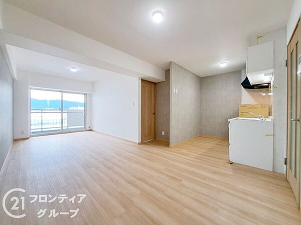 明るい木目のフローリングが美しい、ゆとりあるリビングですね！洗練されたインテリアが映える上質な空間で、窓の外に広がる開放的な景色を眺めながら優雅なティータイムを楽しむのも素敵ですよ