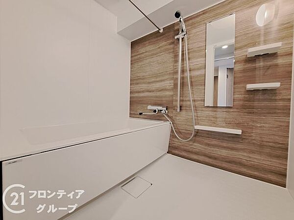 木目調のパネルが高級感を演出するバスルームは、一日の疲れを癒やすためのプライベートな空間です。ゆとりある広さの浴槽で、都心の喧騒を忘れて自分だけの贅沢なリラックスタイムを堪能できます