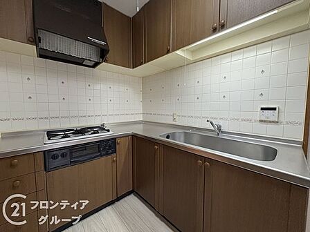 落ち着いたブラウンの木目調パネルが上質なインテリアに馴染む美しい空間ですね!効率的なレイアウトと広めの作業スペースが毎日の調理時間を心地よく快適にしてくれます