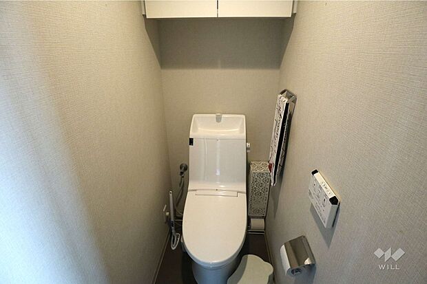 トイレ。上部に吊戸棚があり、ストック品をしっかり収納できます。