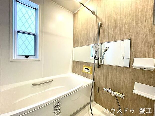 浴室：横長のワイドな鏡と木目の壁面が特徴です。落着いた雰囲気の中で、暖色系のライトがゆったりとした時間を楽しむように雰囲気造りをしてくれています。