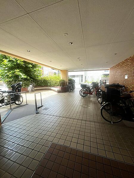 屋根付きの駐輪スペース。植栽やベンチが施されています。