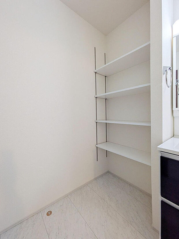 洗面室にはランドリーの収納としても利用可能な可動棚を設置