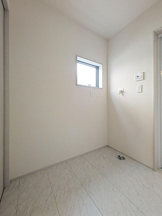 洗面室とは別に大きめの洗濯機置き場＆脱衣所。工夫次第で雨の日などには洗濯物を干すことも可能