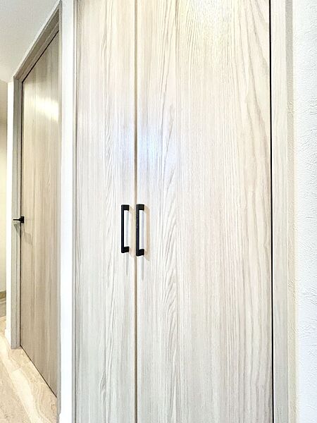 廊下収納。掃除道具や季節の小物を収納することができます。