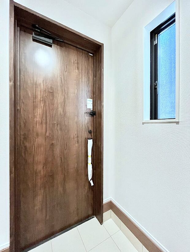 小窓から陽光を感じられる明るい玄関