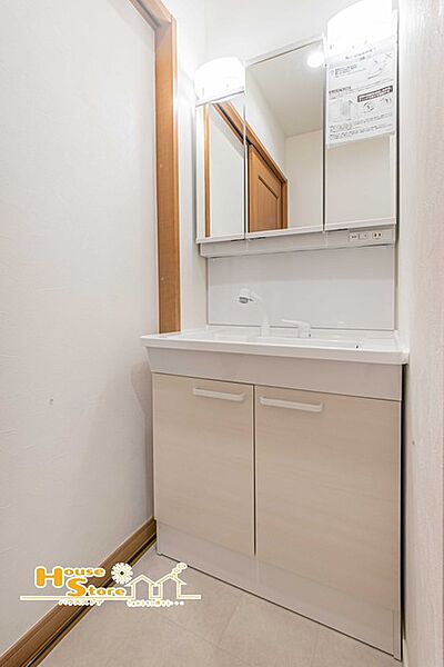 三面鏡とキャビネット収納を備えた洗面台。洗面用品をすっきり整理でき、生活感を抑えながら身支度がしやすい、使い勝手の良い水回りです。