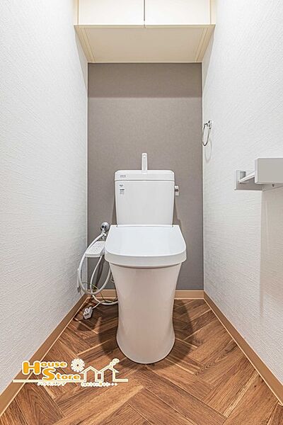 収納棚を備えたトイレはペーパーや小物もスッキリ収納できるので空間を広く使えます。明るく清潔感のある内装で、毎日快適に利用できる空間です。