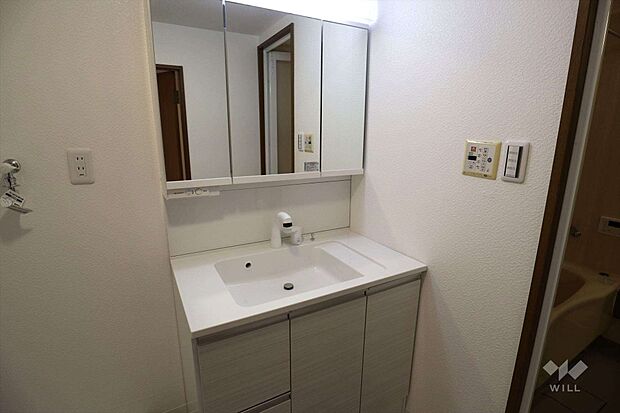 洗面室。鏡横の収納が豊富です。コンセントがあり、身支度に便利です。