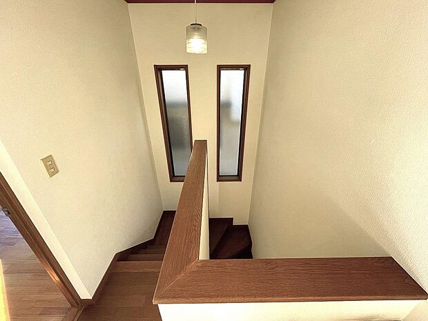 ２階廊下から見た階段スペースは飾り窓が美しく和やかな雰囲気を演出します。ご覧の通り螺旋状の階段ですので比較的安全でお子様やご高齢の方に最適な動線です。階段周りもクロス新調済みです。
