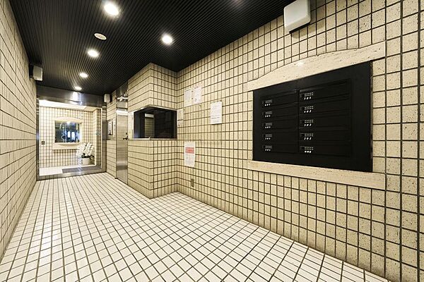 エントランスからロビーへと続く廊下は、重厚な意匠と落ち着いた照明が印象的。日常から静かに切り替わる、趣あるアプローチです。
