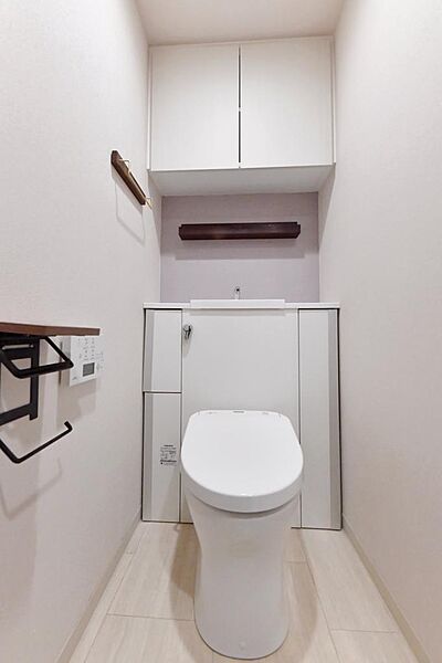 白を基調とした清潔感の高いお手洗い。上部に収納もついておりますので、とても便利です。