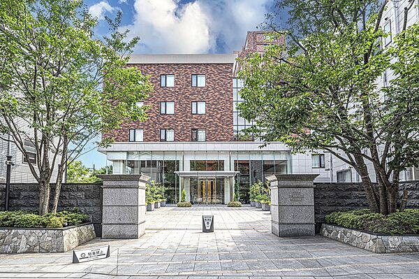 【エントランス】レンガ調のタイルが使用された、重厚感のある外観デザインです。敷地内には植栽が施され、ご家族やゲストをあたたかく迎えてくれます。
