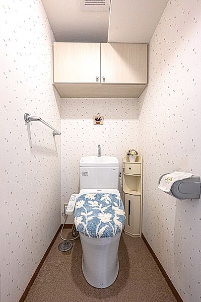 【トイレ】温水洗浄便座が搭載され、一年中快適にご利用いただけます。背面に吊戸棚が設置されており、トイレットペーパーのストックなどを収納していただけます。
