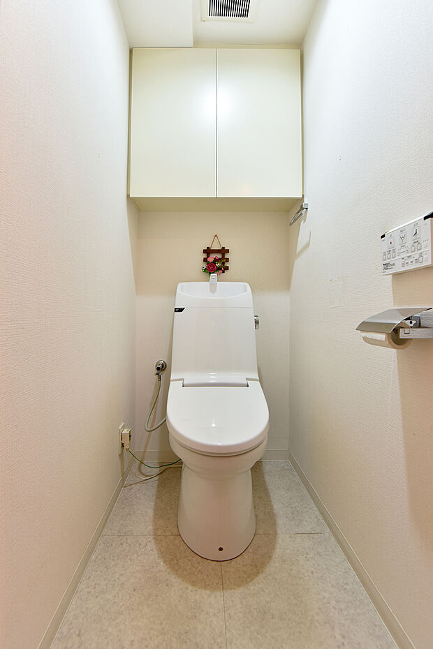 温水洗浄機能付きのトイレには上部吊戸棚があり、掃除用具なども収納可能です。