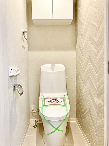 【トイレ】温水洗浄便座付きのトイレです。寒い時期でも暖かな便座で快適に使うことができます。リモコンが壁に設置され、操作しやすい仕様です。