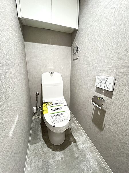 【トイレ】温水洗浄便座付きのトイレは、便器後方に手洗いスペースが備えられた実用的な設計。