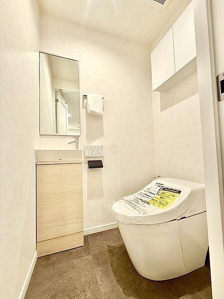 【トイレ】毎日快適にお使いいただける、温水洗浄便座付きのトイレ。収納棚が設置されているので、トイレットペーパーや掃除用具などを収納できます。