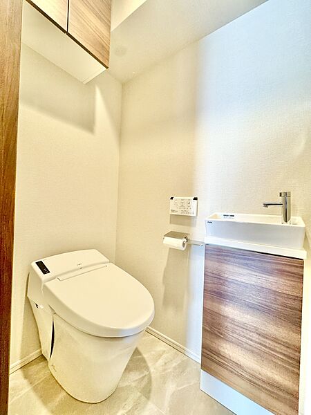 【トイレ】温水洗浄便座付で、毎日快適にお使いいただけるトイレです。掃除用品やトイレットペーパーの保管に役立つ収納が備わっています。