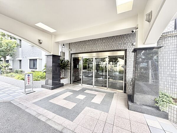 【エントランス】エントランス入口には屋根がありますので、雨の日も慌てずに傘をさすことができます。段差が少なく、ベビーカーや大きな荷物を持っていても移動がスムーズにできます。