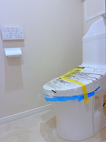 【トイレ】リモコンが壁に設置されているため、座ったままでもスムーズに操作ができます。シンプルなデザインで、日々のお手入れがしやすそうです。