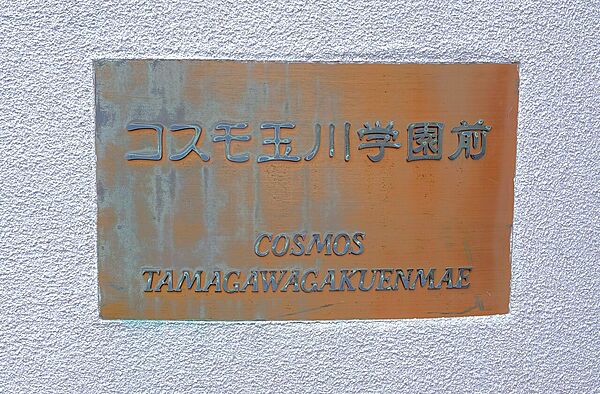 【マンション銘板】マンション名が記されており、来客時などの目印になります。エントランスが2階に設けられているため、階段を使用せずお部屋へ行くことができます。