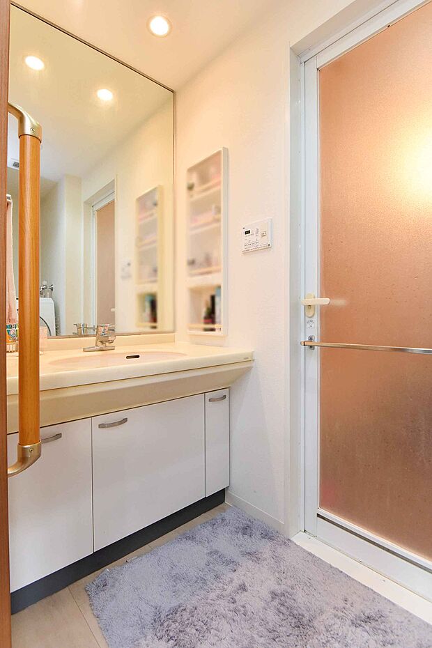 ホワイトを基調とした清潔感のある洗面化粧台がございます。小物の収納に便利な埋め込み式の棚も備え付け。