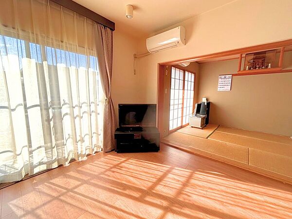 陽光がたっぷり注ぐ明るいリビング。隣接する和室の戸を開ければ、より広々とした開放的な空間が広がります。