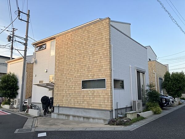 【2020年12月築のスタイリッシュな外観】明るい木目調のアクセントパネルが印象的な2階建て邸宅。東南×西の角地に位置し陽当たり・風通り・開放感ともに優れた恵まれたロケーションです。