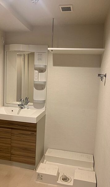 洗濯機置き場の上には、備品の収納に便利な吊り棚付。毎日の生活動線を考えた、使う場所にしまうができる間取です。