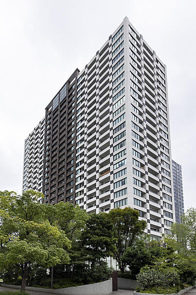 【マンション外観】緑に囲まれた27階建てタワーマンションの外観。存在感のあるファサードデザインが特徴的な建物です。（2026年8月撮影）