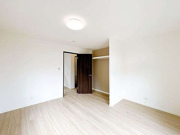 【1階洋室】1階の洋室は8帖の広さです。オープン収納も新設しました。棚をなくしオープンにしたことで、丈の長いコートなどもそのままかけることができますね。